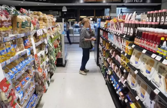 Una mujer mira los precios del supermercado.